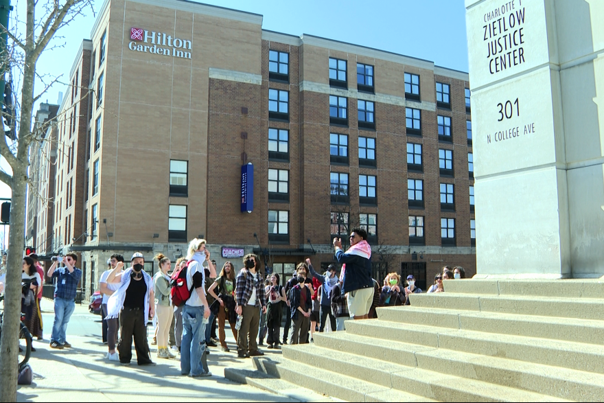 A group organized by IU Divestment Coalition members gather outside the Monroe County Courthouse Tuesday afternoon to protest charges against two members.