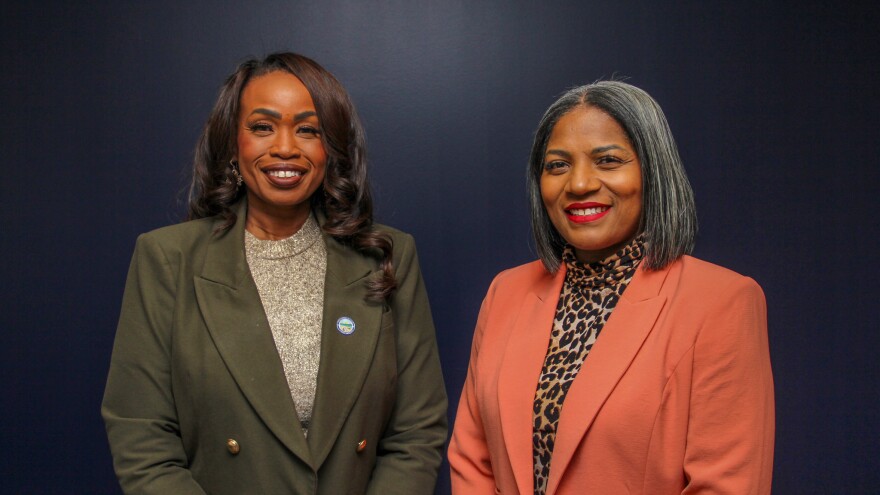 Two well-dressed women pose for a photo.