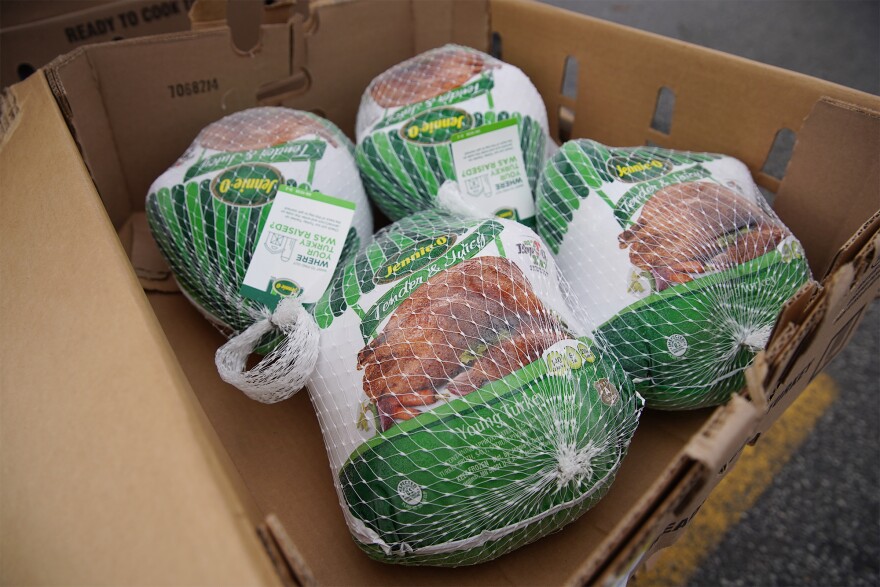 Four frozen turkeys are in a box ready for distribution.