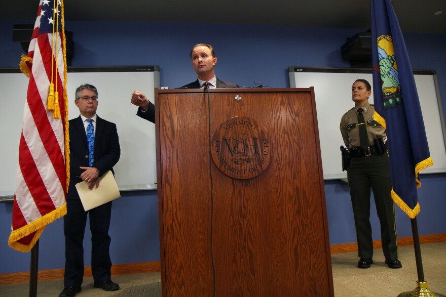 Three people stand by a podium.