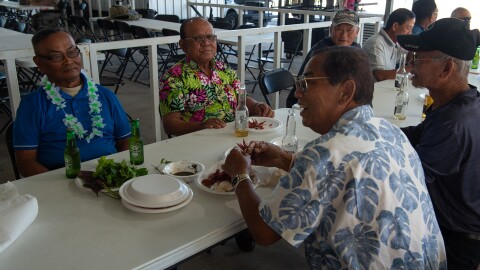 At a family event hosted by the Wat Thammarattanaram, Laotian men eat crawfish served alongside traditional Laotian and Vietnamese dishes.