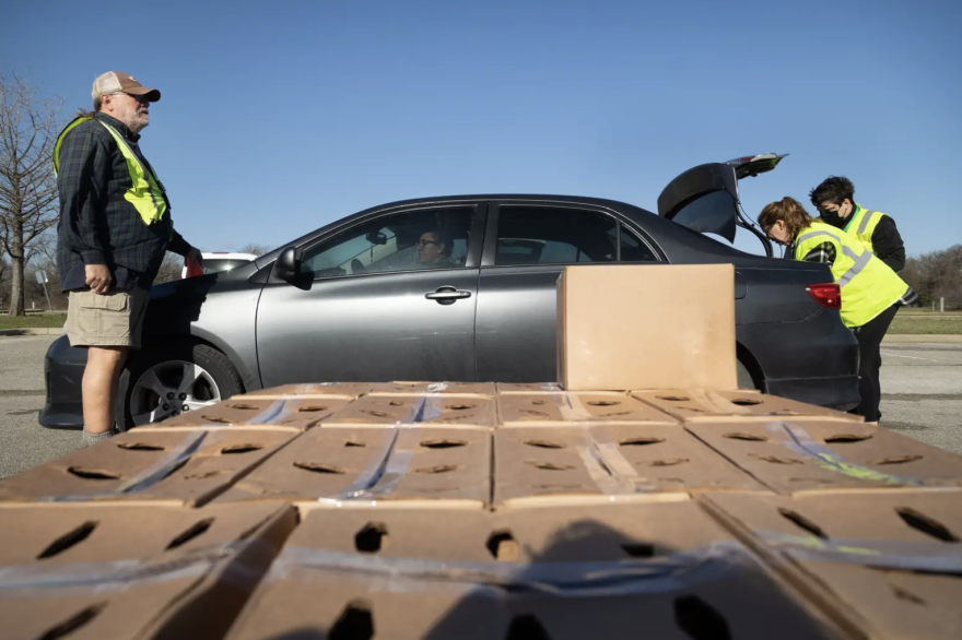 From left: Ross Fields, Susan Morgan and Baron Reedy work to load boxes into the trunk of a vehicle at the Onion Creek Soccer Complex in Austin. The Central Texas Food Bank operated 56 drive-thru events across the state in March.