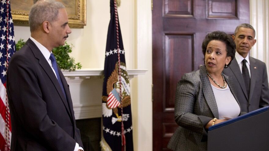 U.S. Attorney General nominee Loretta Lynch, center, looks to outgoing Attorney General Eric Holder as President Obama stands nearby Nov. 8 in the Roosevelt Room of the White House.