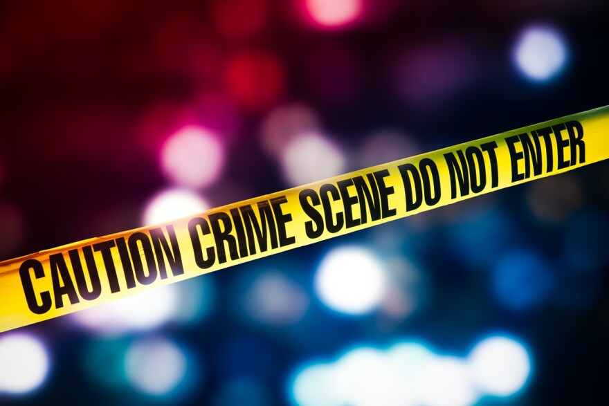 Crime scene tape with red and blue lights in the background