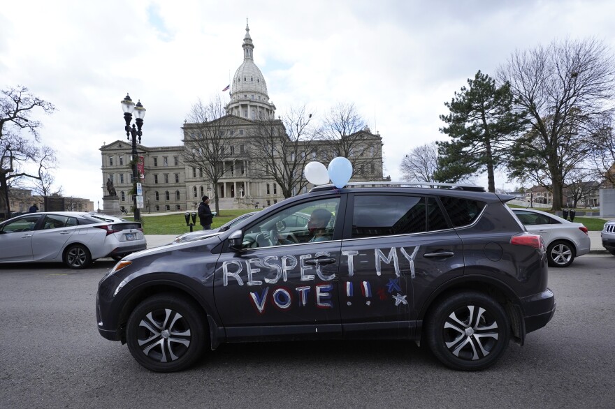 A motorist participates during a drive-by rally to certify the presidential election results near the Capitol building in Lansing, Mich., Saturday, Nov. 14, 2020. (AP Photo/Paul Sancya)