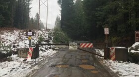 A gate with a "road closed" sign