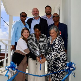 Pictured: Tropical Shipping representatives cut the ribbon to their new administrative and warehouse facility, joined by contractor James Benton, pictured in the back row.