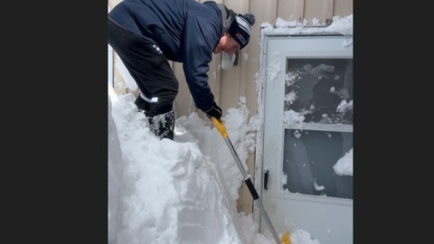 Chelan Gonzalez, a Room at the Inn street outreach team member, digs out a doorway to one of the group's family shelters, in March, 2026.