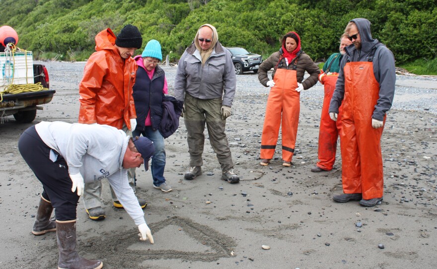 Brian Gabriel (left) draws a diagram explaining the mechanics of a beach seine pully system on Wednesday, July 9, 2025 in Clam Gulch, Alaska.