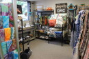 A cozy corner of a thrift store with tie-dyed items, handmade rugs, pillows and more. 