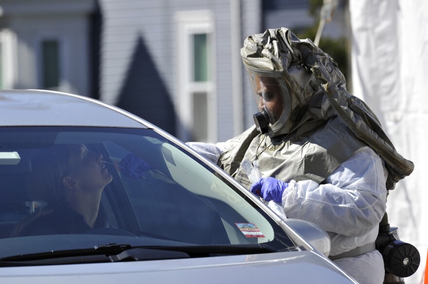 A medical personnel member takes samples of person at a "drive-thru" coronavirus testing lab set up at Somerville Hospital in Somerville, Massachusetts. (Joseph Prezioso/AFP via Getty Images)