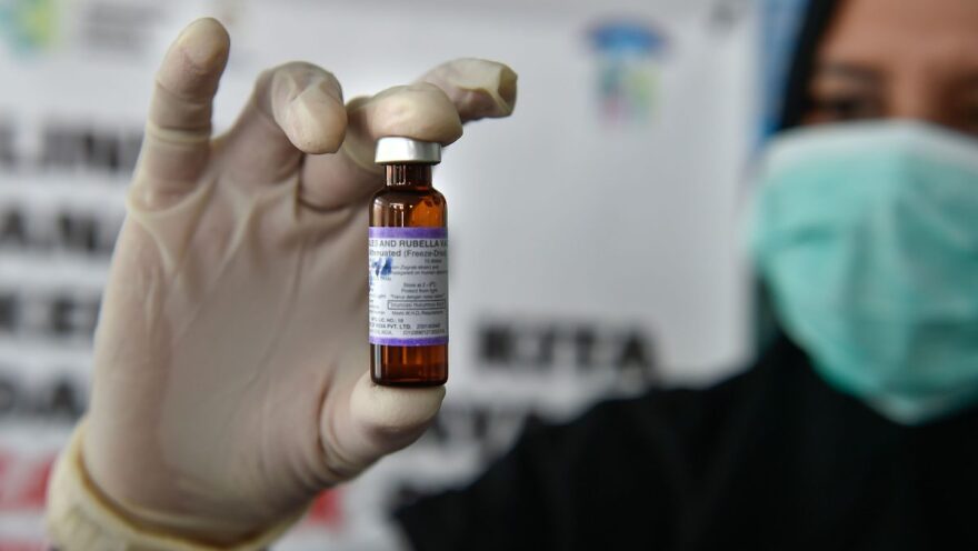 A medical worker holds a measles-rubella vaccine at a health station in Banda Aceh, Indonesia.