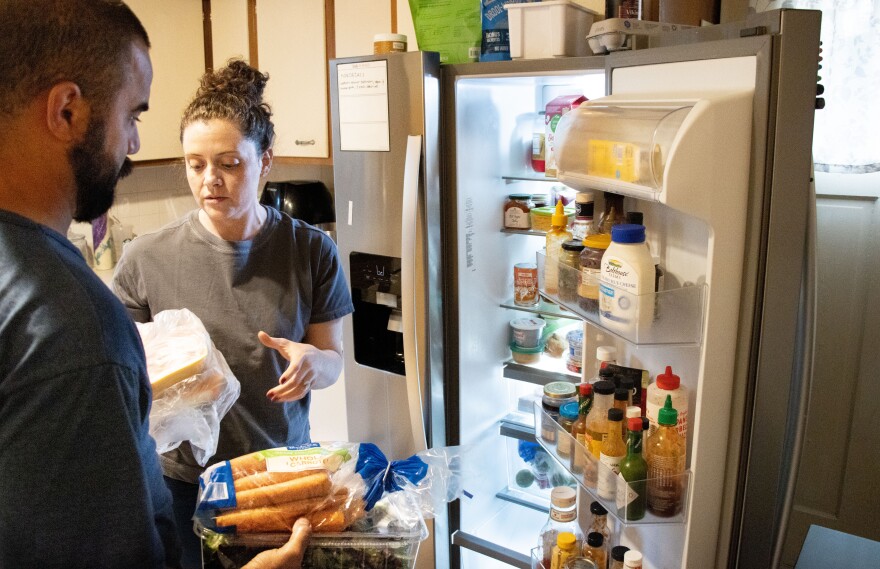 Josué 'Z' Barros and spouse Carrie Barros of Evansville, stock the fridge after a shopping trip. A family of six with four teens/preteens, they can't afford to waste food. Carrie said she often under-shops for groceries to avoid waste. Experts think many families have poor inventory management skills, which leads to food waste.