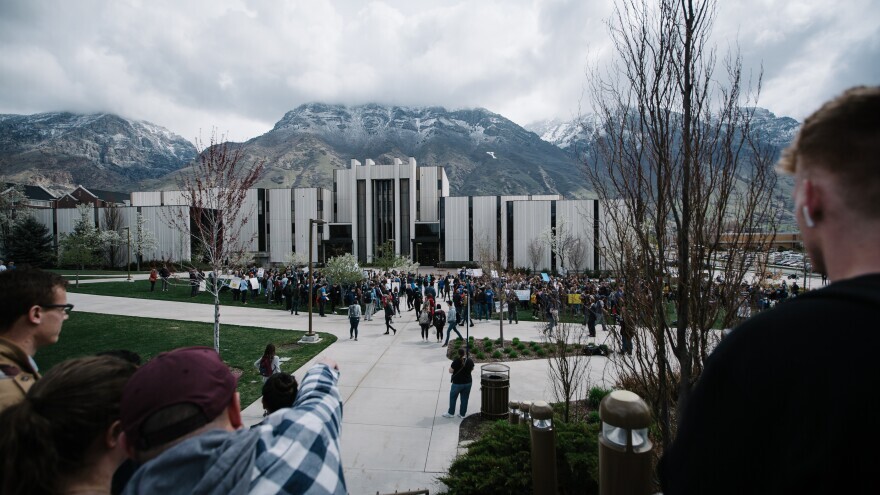 Brigham Young University's Y Mountain is visible in the distance as a 2019 campus protest about its policies toward LGBTQ students takes place.