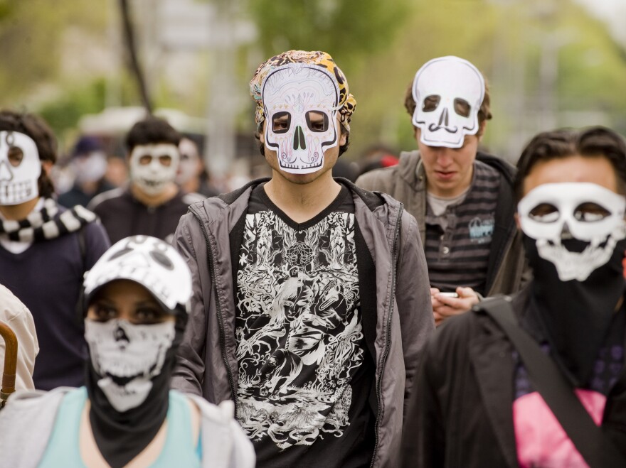 Mexicans wearing masks of skulls protest against violence in the country, in Mexico City, Nov. 27, 2011. More than 50,000 people have been killed in rising drug-related violence in Mexico since December 2006.