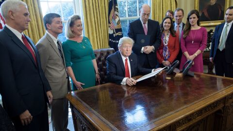 President Trump waits to sign an executive action directing the Treasury secretary to review the Dodd-Frank financial oversight law in the Oval Office on Friday.