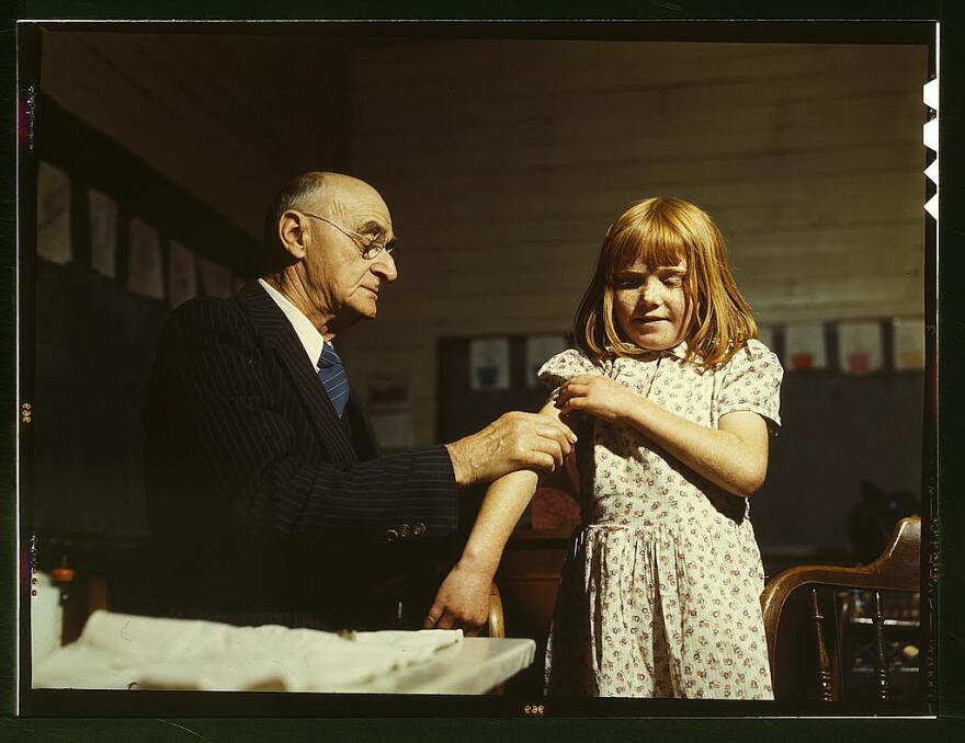 Dr. Schreiber of San Augustine giving a typhoid innoculation at a rural school, San Augustine County, Texas, circa 1939