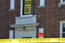 A bright orange signs warns people not to enter the buildings.