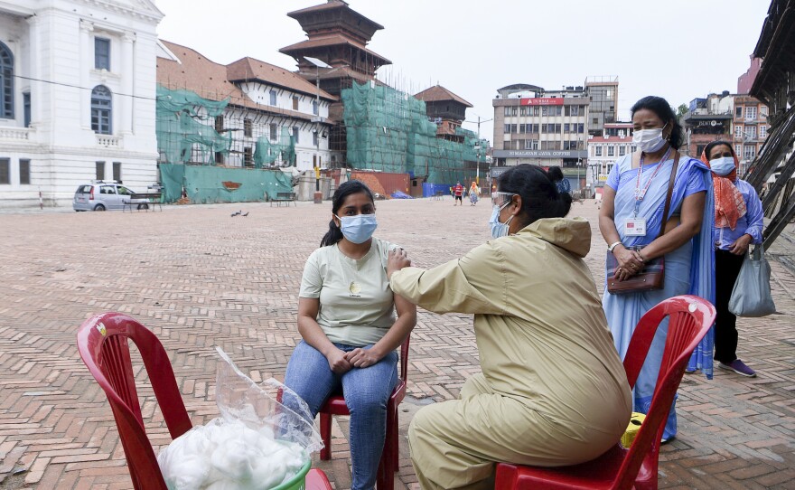 A health worker inoculates a woman in Kathmandu with a Chinese-made vaccine.