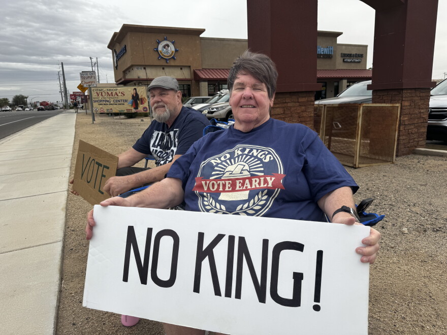 Karla Gommel to the right sitting with her banner.