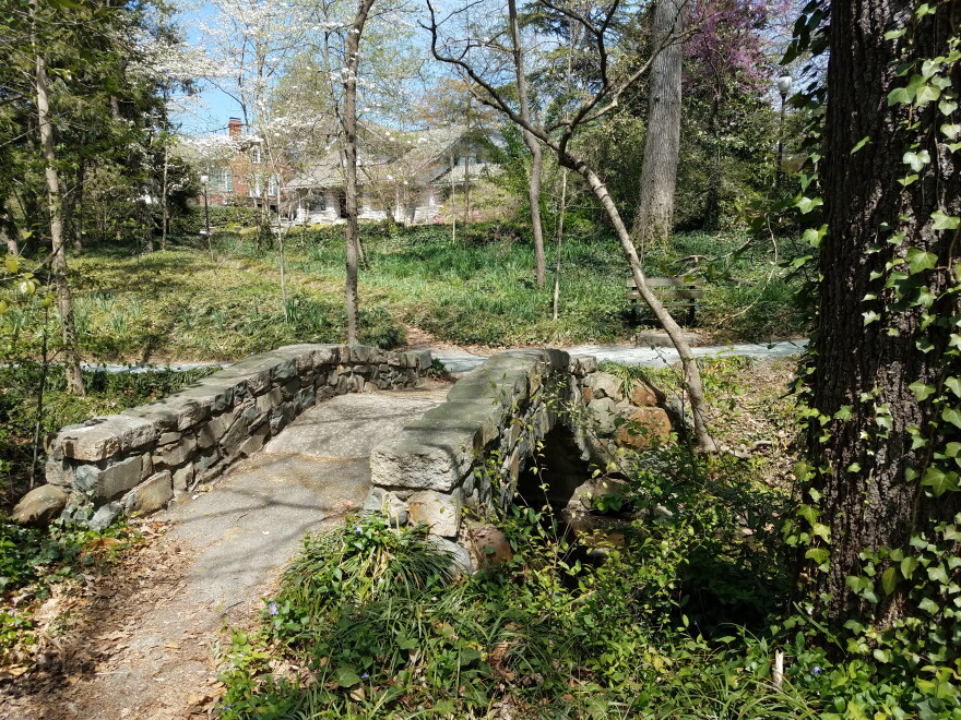 A stone bridge and wooded area in Fisher Park. 