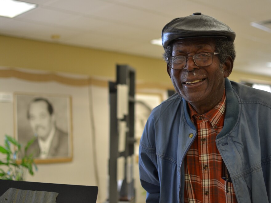 Mitch Williams, 85, grew up in Mound Bayou and became a patient after Delta Health Center opened. He later got a job at the health center and now serves on the clinic's Board of Directors. He was photographed in an exhibit of the clinic's history, near a portrait of Andrew James, who was the center's director of environmental improvement.