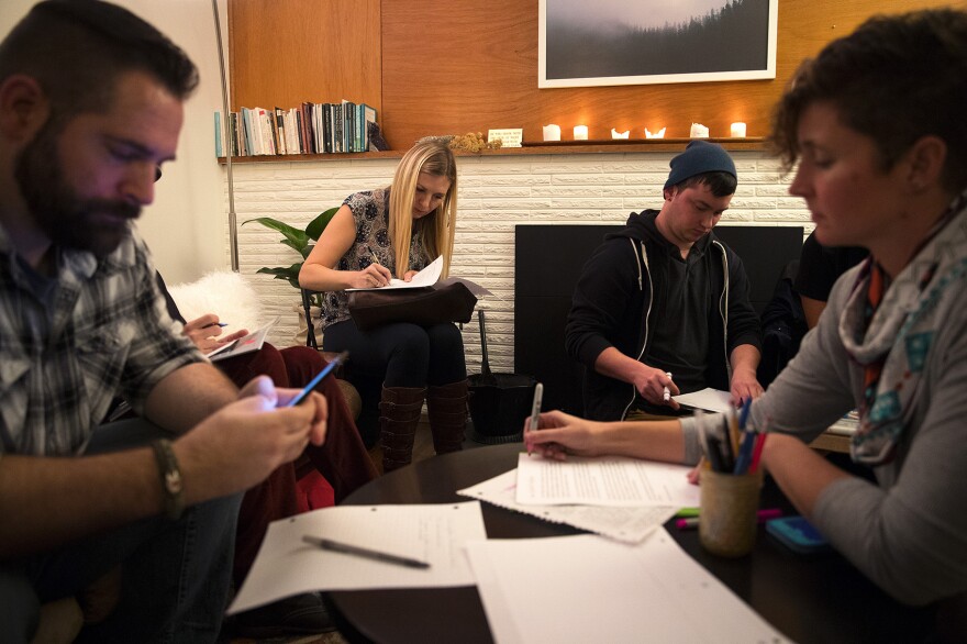 From left, James Marx, Carrie Howell, Robin Mueller and Haley Ballast write letters of support after a flier from the group Respect Washington circulated Burien, on Monday, October 30, 2017, in Burien.