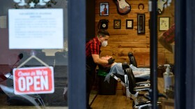 A barber attends a client after reopening his barber shop on May 4, 2020. (Pierre-Philippe Marcou/AFP via Getty Images)