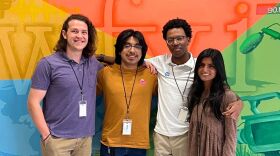 Interns posing in front of colorful WFYI lobby mural