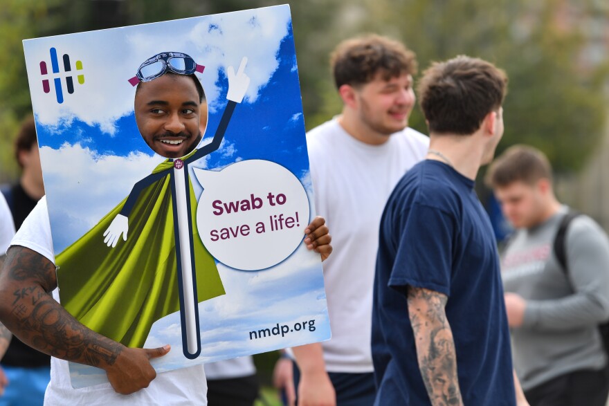 Kevin Knox, a freshman football player at Wilkes University, holds a sign to encourage students to sign up to the bone marrow registry.