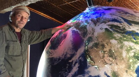Artist Eric James Morris points out Fairbanks on a giant spherical model of Earth at the soon-to-be opened Aurora Discovery Institute at Pike's Waterfront Lodge in Fairbanks.