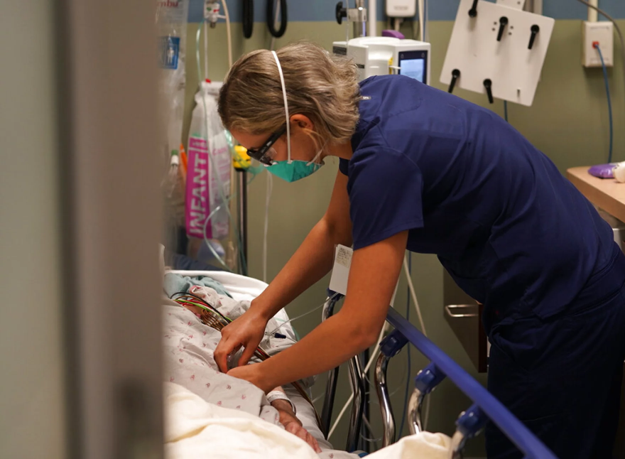 Registered nurse Sandra Younan adjusts an intravenous line for a patient at the emergency room of Providence Cedars-Sinai Tarzana Medical Center in the Tarzana neighborhood of Los Angeles on Thursday, March 11, 2021. (AP Photo/Damian Dovarganes)