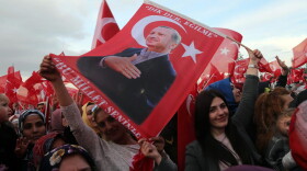 Supporters of the "yes" vote wave Turkish National flags and flags depicting Turkish president Recep Tayyip Erdogan as they cheer during his speech at the Presidential Palace in Ankara, on April 17, 2017, following the results in a nationwide referendum. (Adem Altan/AFP/Getty Images)