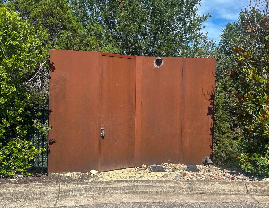 A fence outside of a West Lake Hills home linked to Elon Musk on June 10, 2025. Lauren McGaughy/The Texas Newsroom