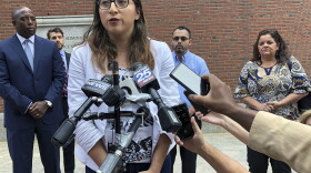 Lilian Calderon answers questions during a lunch break outside Boston federal court on Monday. The American Civil Liberties Union argued a case on behalf of couples that federal immigration officials are violating the rights of immigrants seeking legal status by setting a deportation "trap" at their required marriage interviews. (Philip Marcelo/AP)