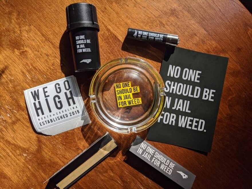 Cannabis containers and advocacy materials reading 'No one should be in jail for weed.'