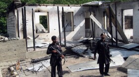 Pakistani security personnel stand guard in front of a burnt-out school following an attack by the Pakistani Taliban in the northwestern district of Upper Dir in June 2011. The Taliban have destroyed many schools in northwestern Pakistan.