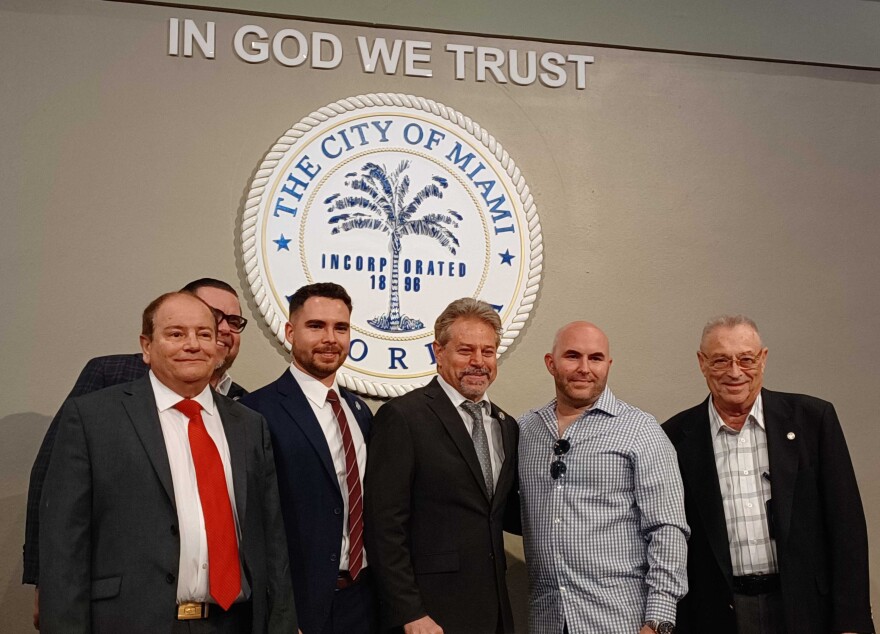 Funcionarios frente al sello de Miami