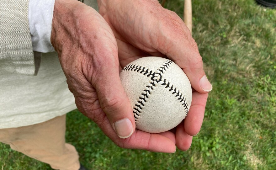 A vintage "lemon peel" baseball designed with a distinctive X-pattern stitching.