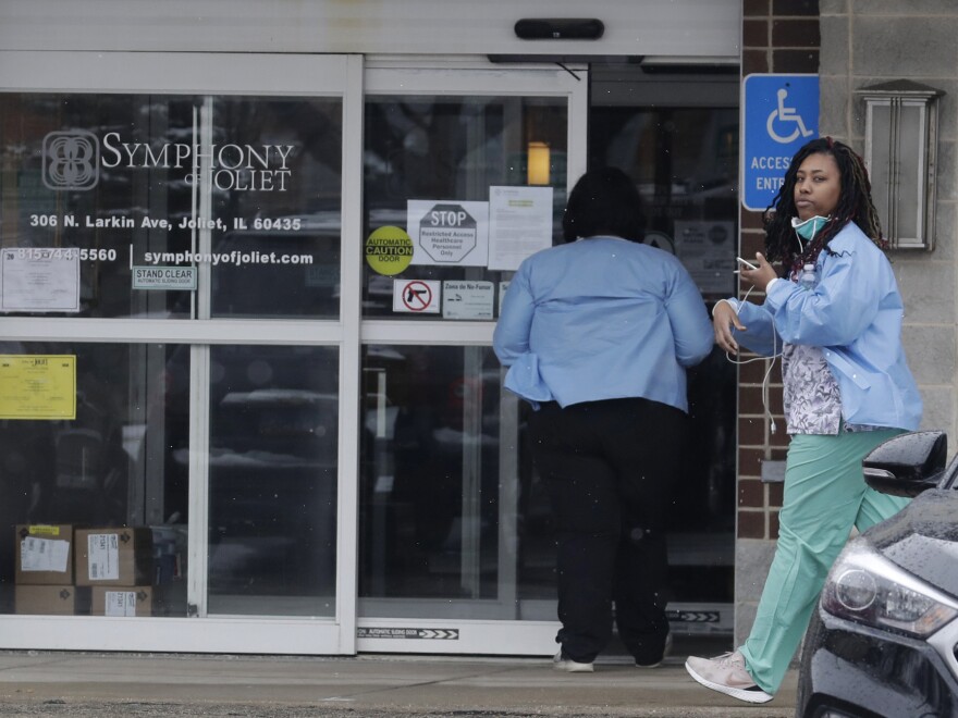 Employees of the Symphony of Joliet nursing home in Joliet, Ill., go to work last Friday. At least 21 people, including two staff members, have died of COVID-19 at the facility.