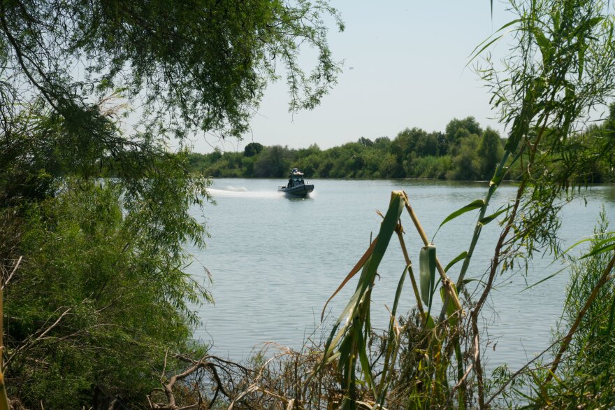 A U.S. Customs and Border Protection boat plies the waters of the Rio Grande near the edge of the National Butterfly Center.