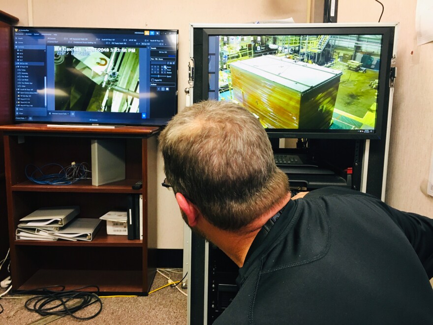 The back of a man's head watching two screens.