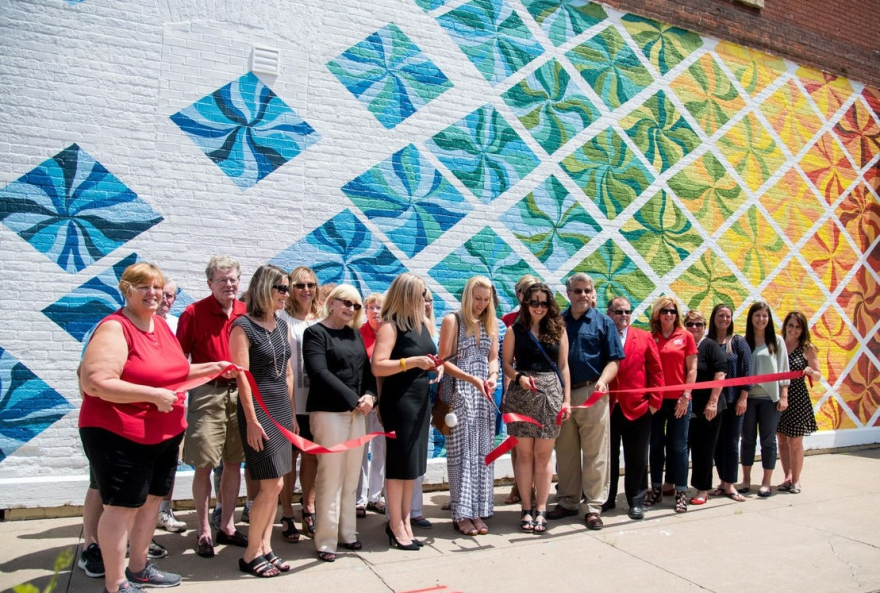 cutting the ribbon for a downtown mural, from the university-Clinton partnership in 2018