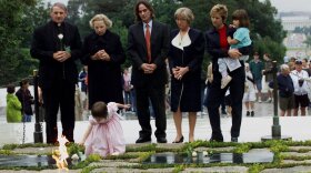 Robert F. Kennedy's granddaughter, Saoirse Kennedy Hill, places a flower at the Eternal Flame, President John F. Kennedy's gravesite in Arlington, Va., in 2000. Hill died Thursday at age 22.