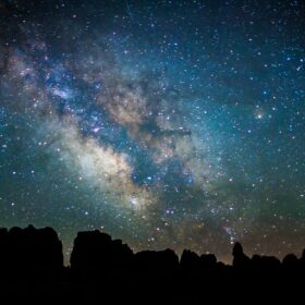 Milky way above Chesler Park, Canyonlands National Park with silhouette of a mountain in the foreground    