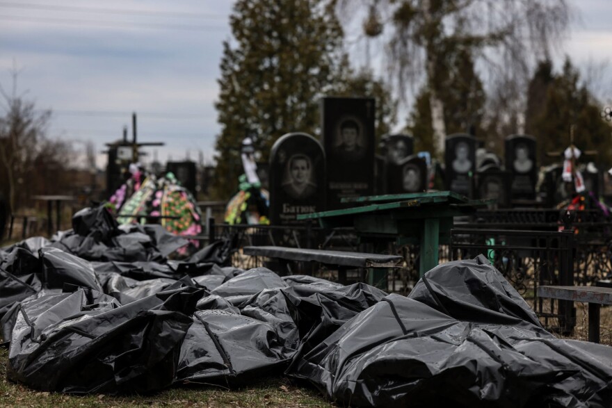 Body bags are lined up for identification by forensic personnel and police officers in the cemetery in Bucha, north of Kyiv, on April 6, 2022, after hundreds of civilians were found dead in areas from which Russian troops have withdrawn around Ukraine's capital, including the town of Bucha. (Ronaldo Schemidt/AFP via Getty Images)