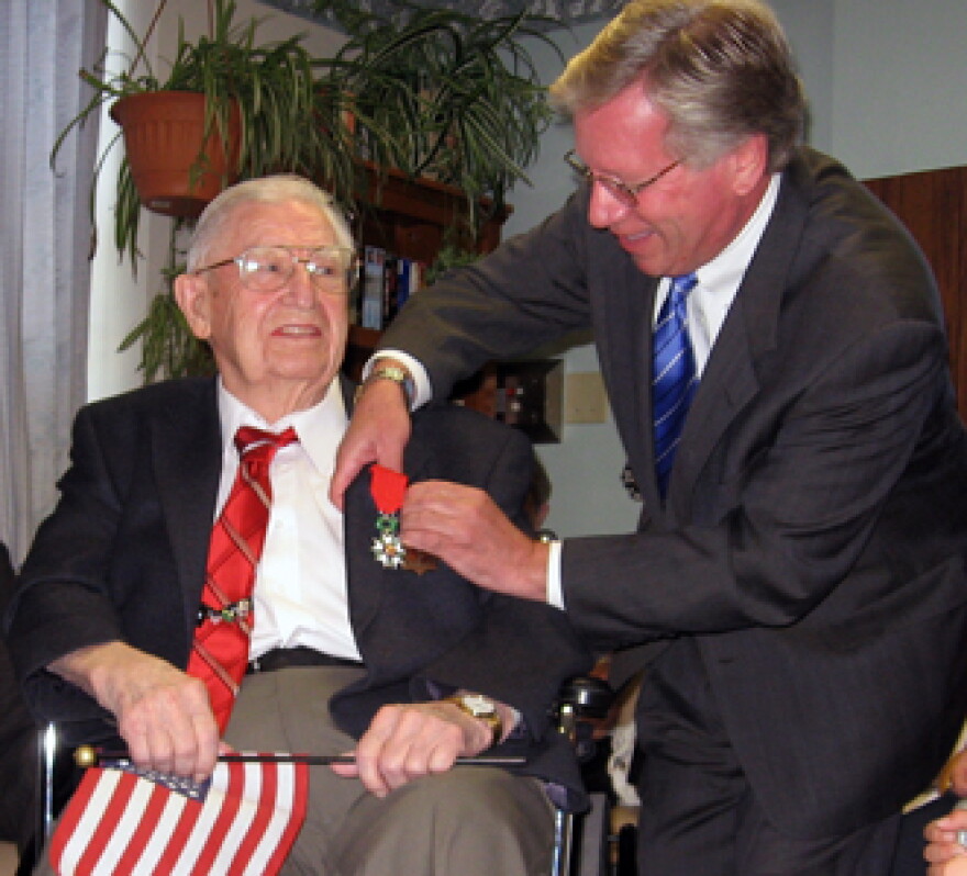 Robin Schimminger presents Pawlik with an award on behalf of the New York State government.