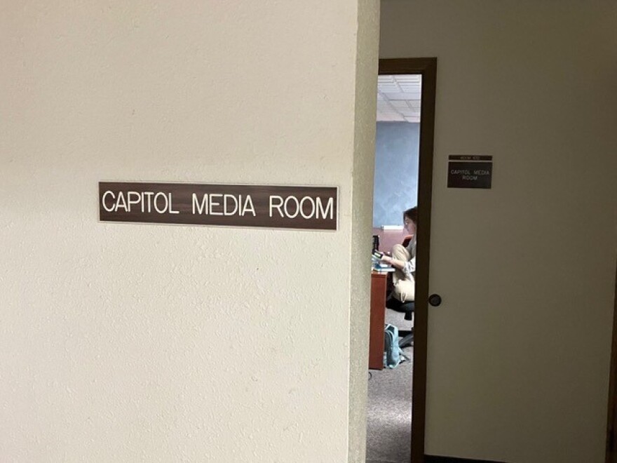 A barely visible Annie Todd of the Argus Leader works a her desk in the new Capitol press room