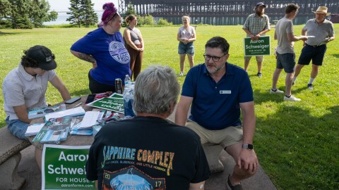 Aaron Schweiger, a Democrat running for Minnesota House District 3B, talks with attendees before canvassing a neighborhood in Two Harbors, Minn., on July 19, 2026.