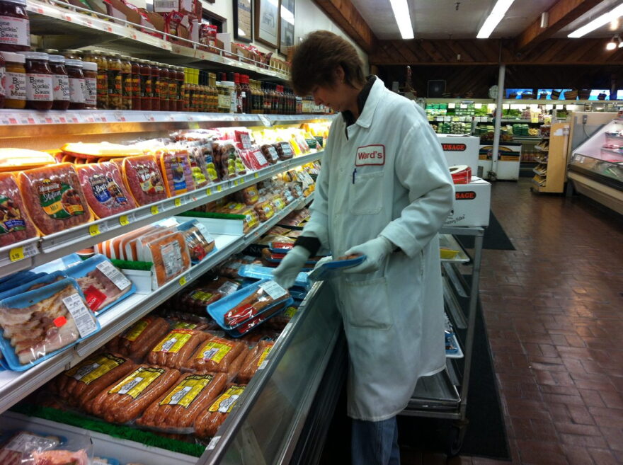 A Ward's Supermarket employee stocks the meat section Wednesday ahead of the July 4 holiday.